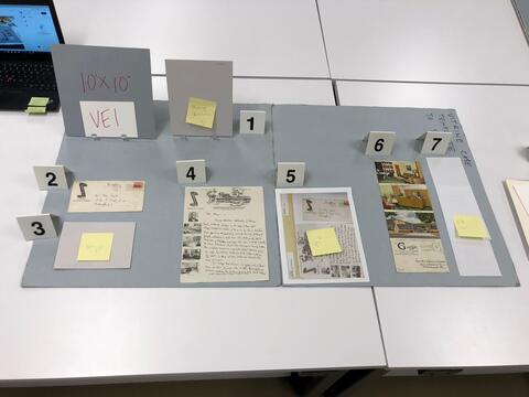 Layout planning photo of all items to be included in the first vintrine case on the east side of the Beinecke Library. 