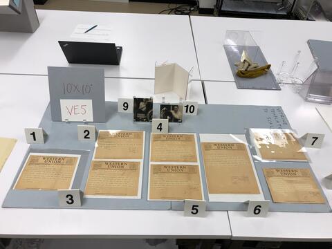 Layout planning photo of all items to be included in the fifth vintrine case on the east side of the Beinecke Library. 